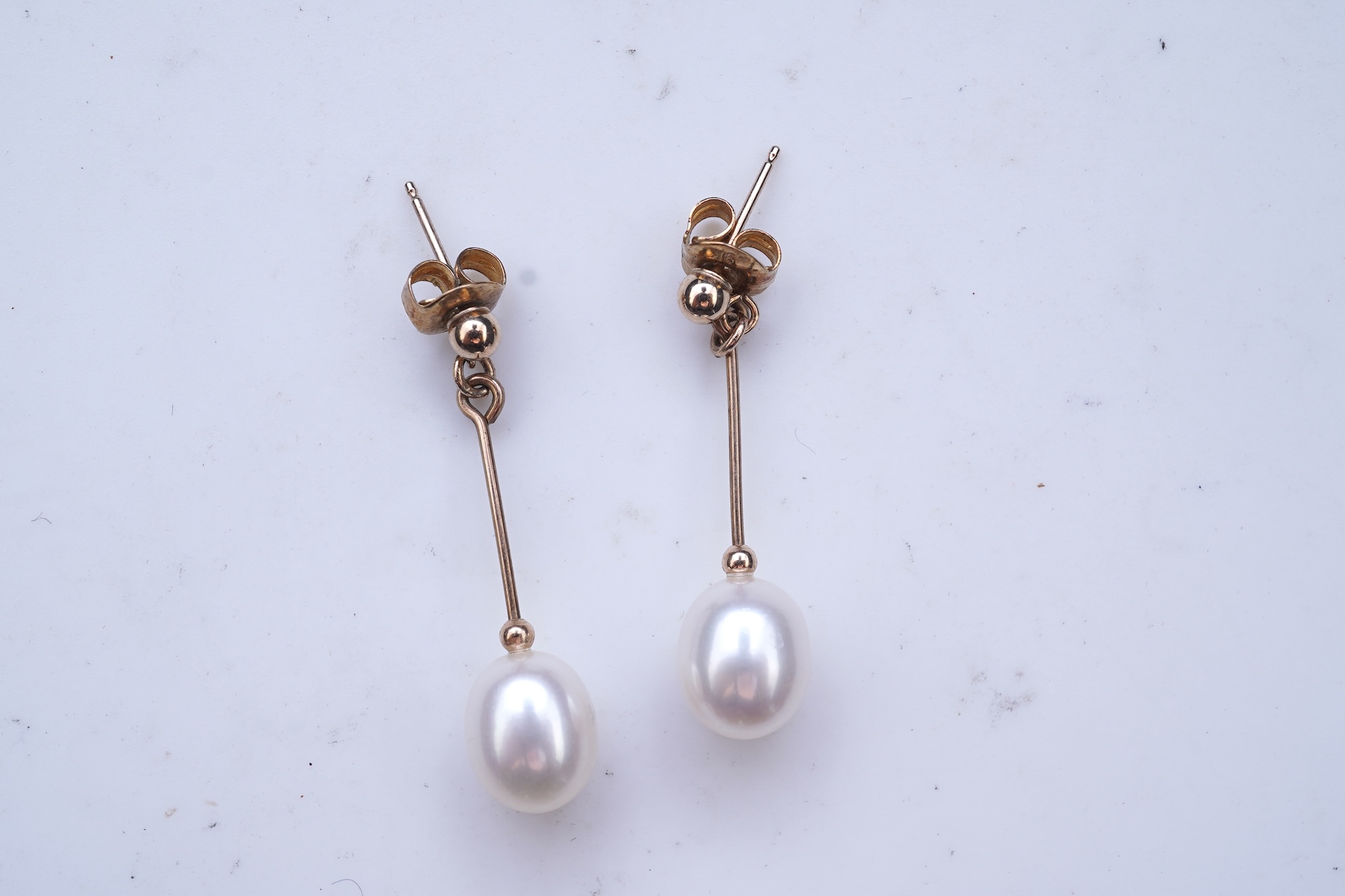 A group of cultured pearl jewels, comprising: two pairs of cultured pearl drop earrings, longest 3cm, mounted in gold; and two cultured pearl brooches mounted in 9ct gold, longest 4.1cm, British hallmarks, combined gross